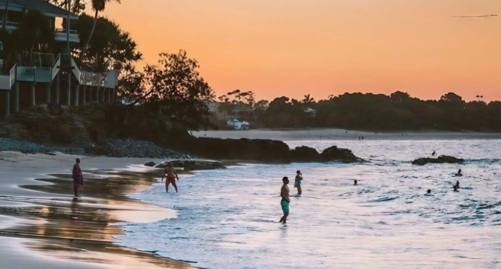 people swimming in little cove beach accommodation