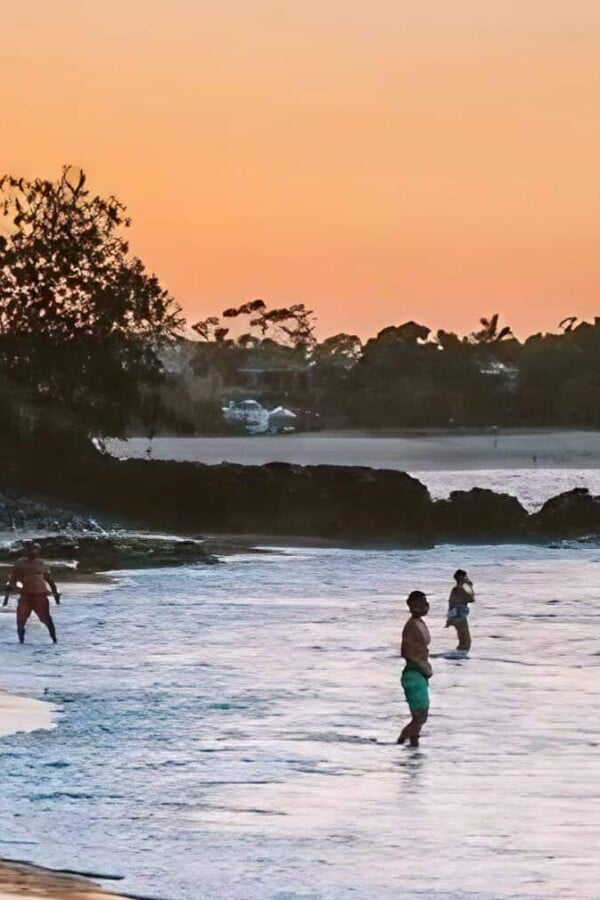 people swimming in little cove beach accommodation