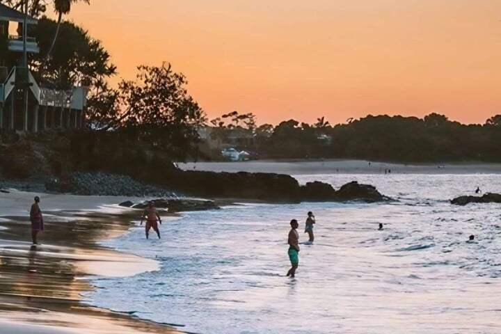 people swimming in little cove beach accommodation