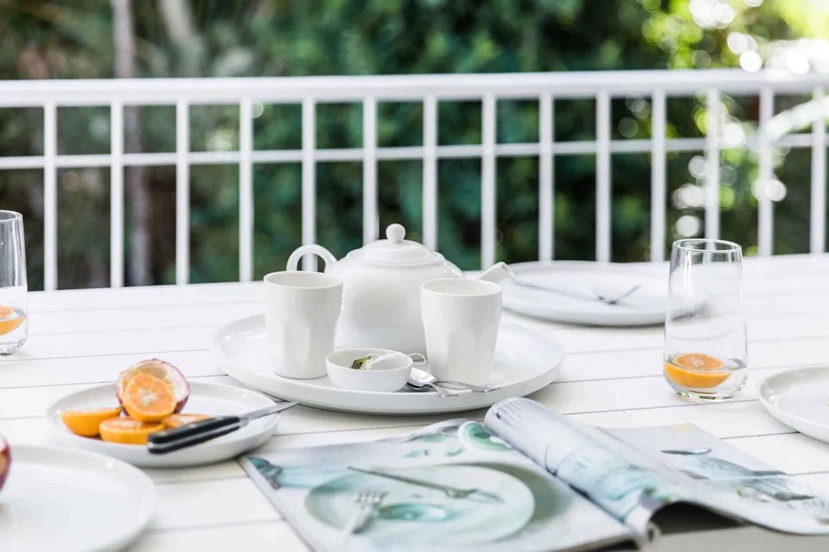 outdoor breakfast setting at a Noosa holiday home surrounded by greenery